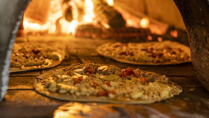 three pizzas cook in a woodfire oven | pizzerias in Charlotte