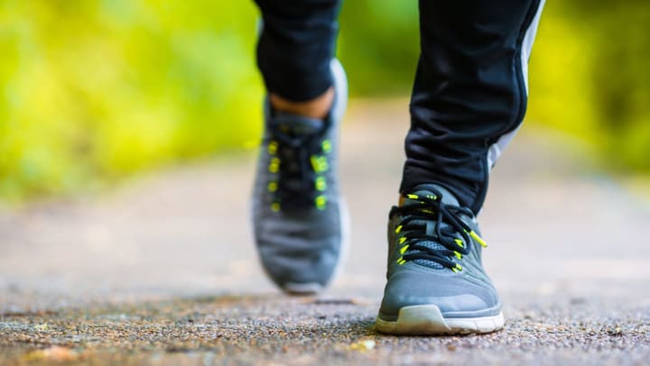 Closeup on sneakers of a man going for a walk