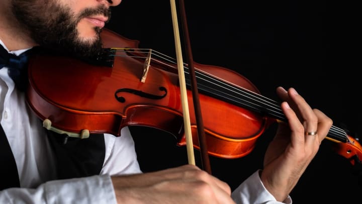 Elegant man playing the violin at a concert | fayetteville symphony orchestra