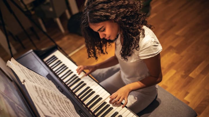 Woman in a studio learning to play the piano | music schools near Phoenix