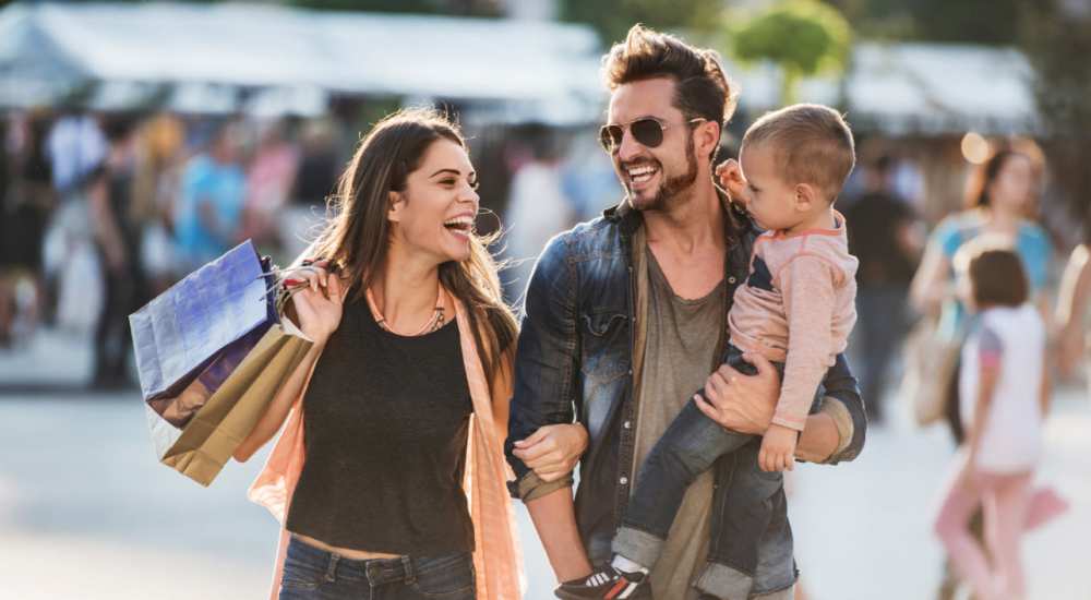 Happy family enjoying shopping near Grove Station Tower in Miami, Florida