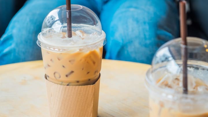 iced coffee in a plastic cup with a straw on a table | coffee shops in Flagstaff