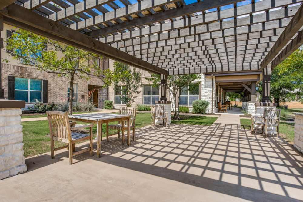 Scenic patio area with shaded seating near Isle at Cedar Ridge in Cedar Park, Texas.