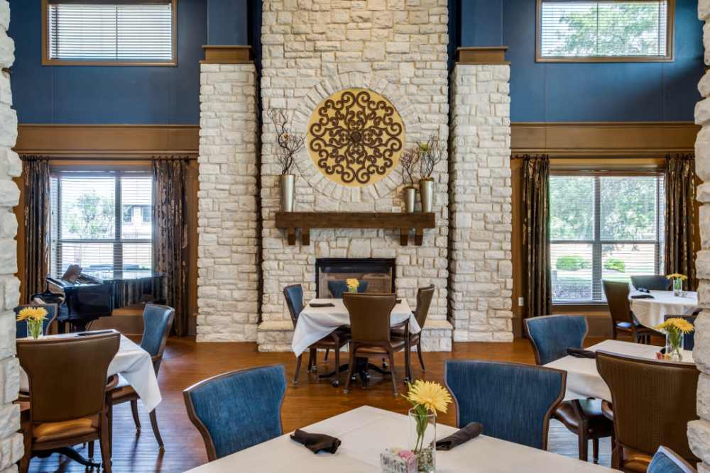 A fire pit with dining tables arranged in front of it at Isle at Cedar Ridge in Cedar Park, Texas