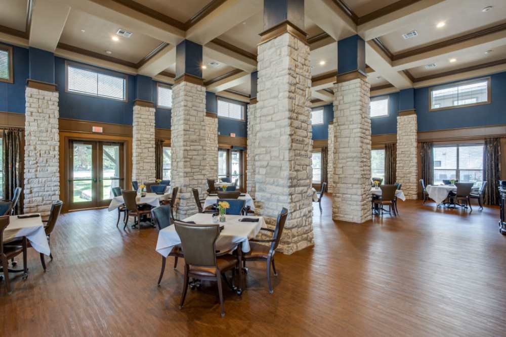 A few couches around an ottoman with a bookshelf behind them at Isle at Cedar Ridge in Cedar Park, Texas