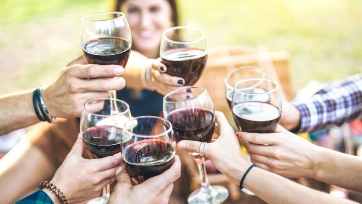 Hands toasting glasses of red wine | events in Santa Fe