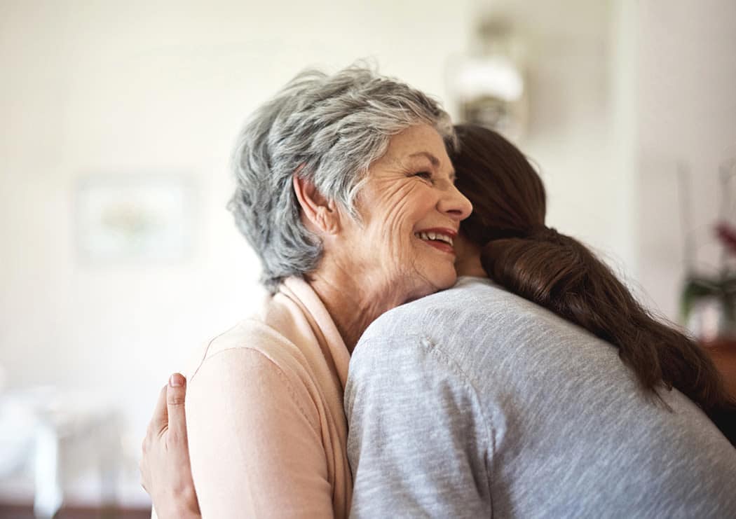 Elderly woman hugging at Iris Memory Care of Edmond