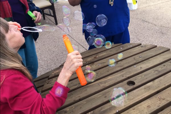 Women blowing bubbles at Woodland Palms Memory Care