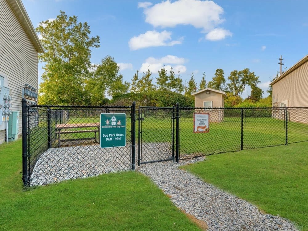 Dog park with fenced area and gravel path at River Club in Holland, Michigan