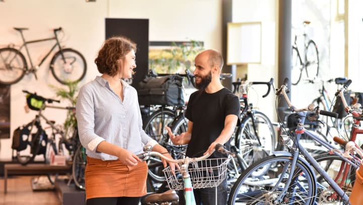A man and woman discuss a bike in a bike shop in Richmond.