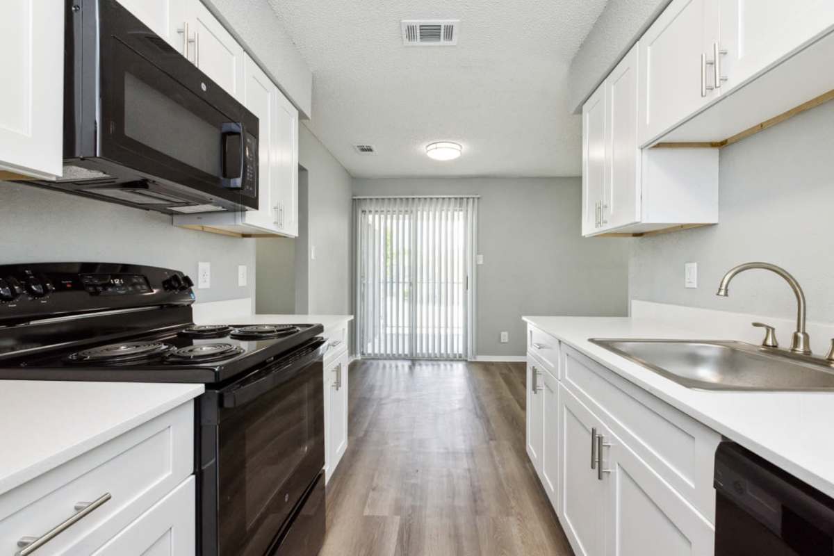 Modern kitchen with wood-style flooring at Stonehill in Killeen, Texas