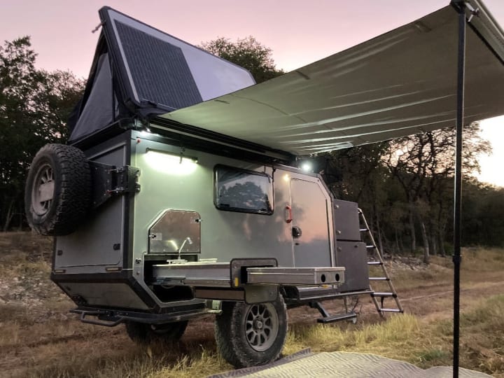 Adventure camper with canopy at dusk