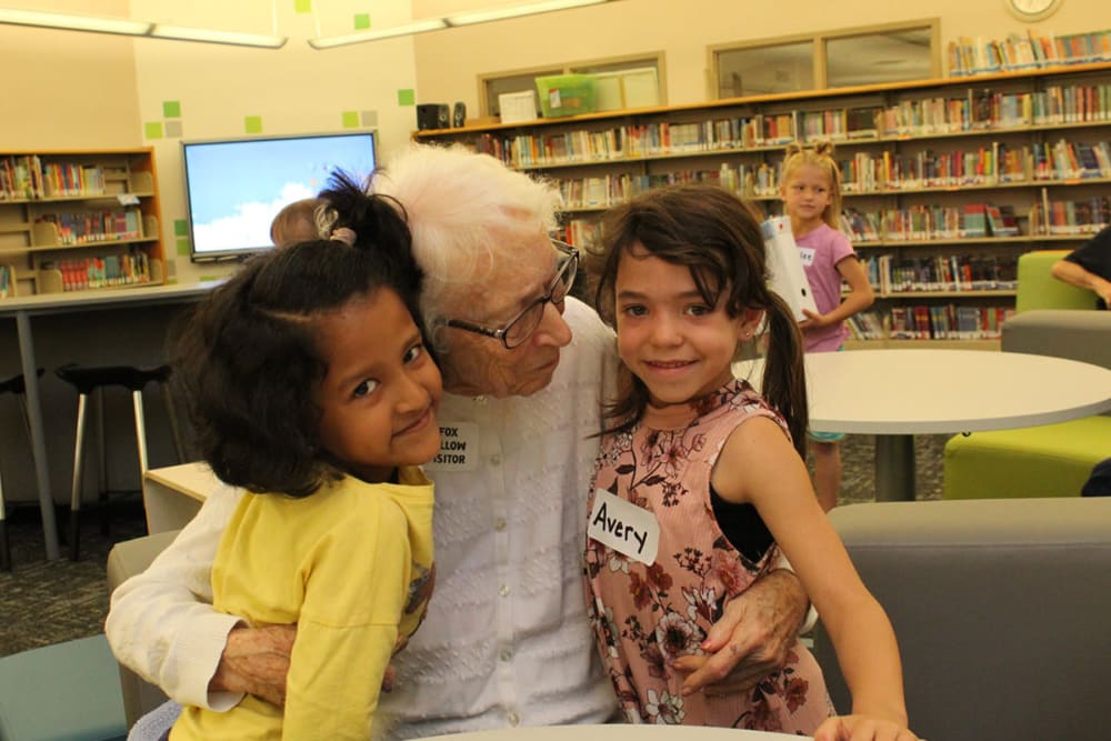 senior resident receiving a hug from children