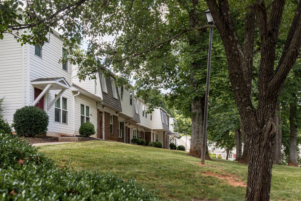 Beautiful exteriors with patios and a green lawn at Old Mill Townhomes in Lynchburg, Virginia