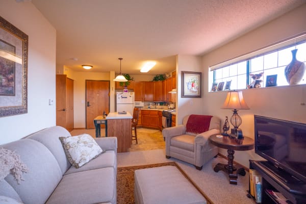 Senior resident aparment living room with furniture and large windows at Meadows on Fairview in Wyoming, Minnesota