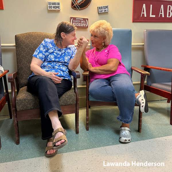 Resident and caregiver Lawanda clasping hands in friendship
