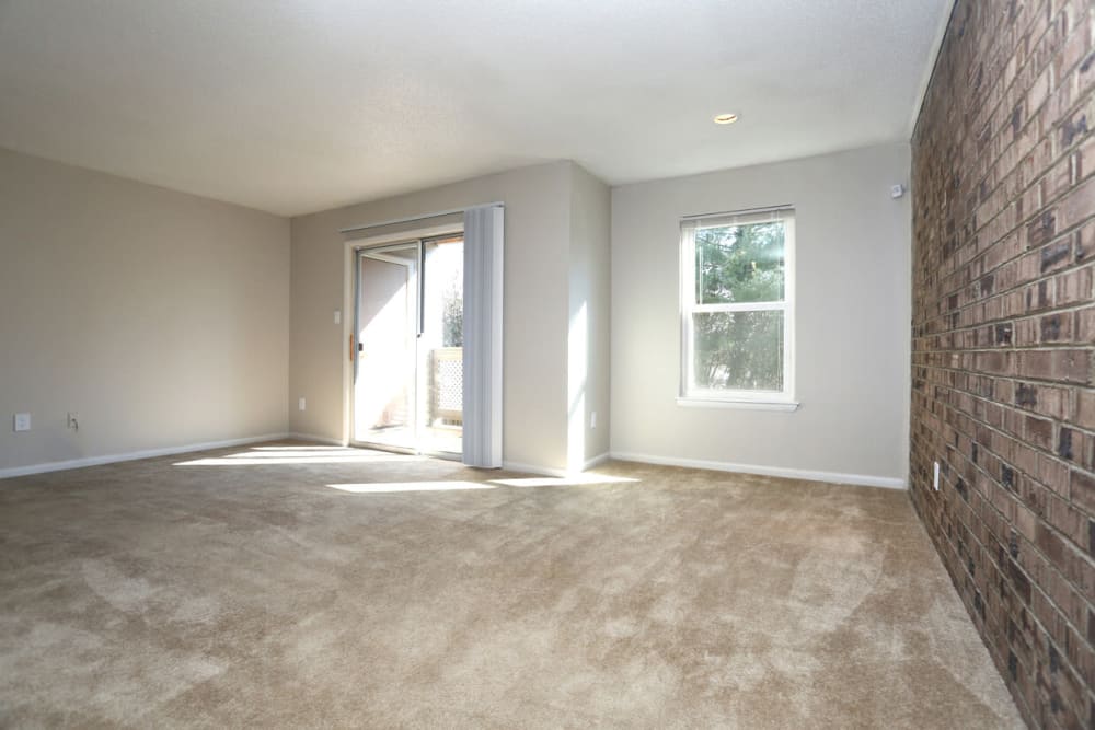 Spacious living room opening onto a private balcony at Laurel Pines Apartments in Richmond, Virginia