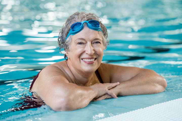 Senior woman in swimming pool smiling