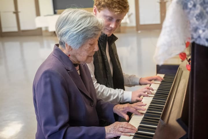 Senior woman playing piano with activities director