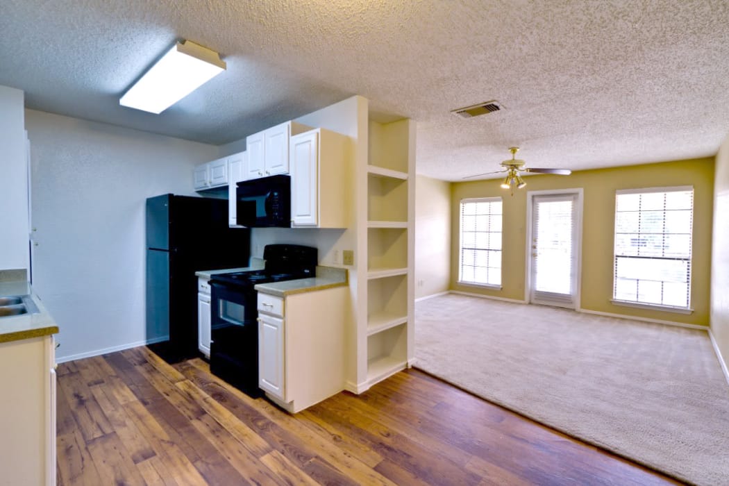 Modern kitchen with hardwood floors in model home at The Arbors of Carrollton in Carrollton, Texas