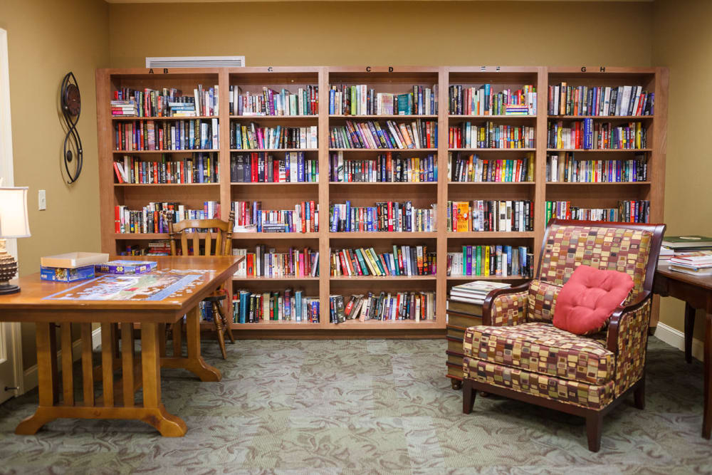 A library with cozy seating at Harmony at Falls Run in Fredericksburg, Virginia