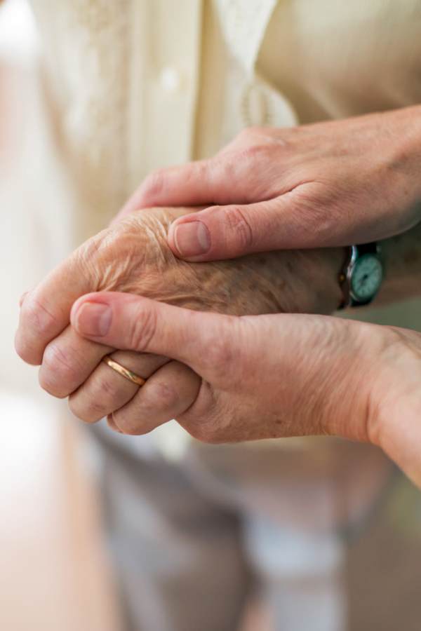 Resident holding hands with family at Merrill Gardens in Seattle, Washington