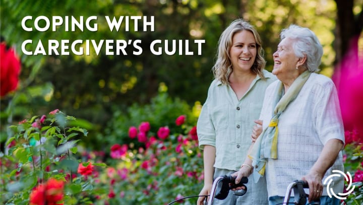 Caregiver walking with a senior citizen through a rose garden.
