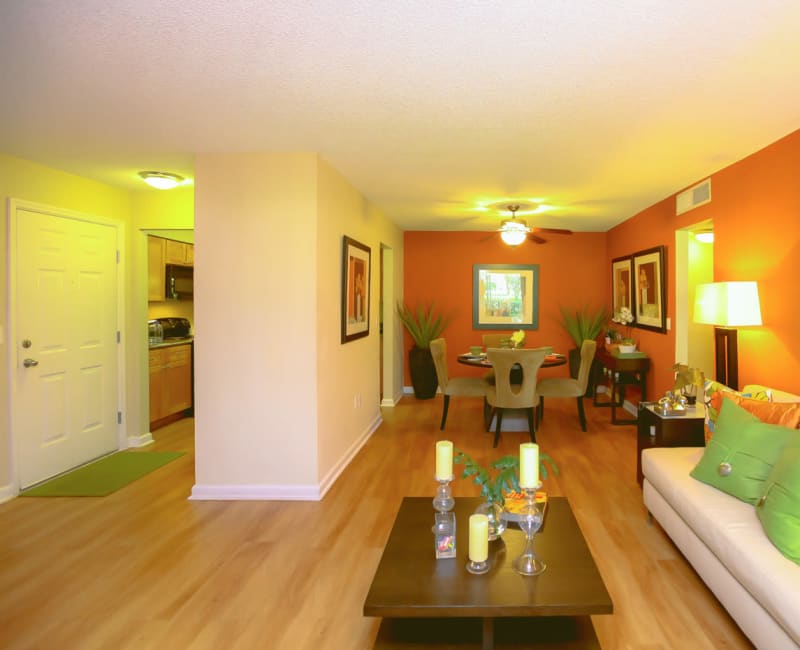 Comfortably decorated living area with hardwood floors in a model home at Signal Pointe Apartment Homes in Winter Park, Florida