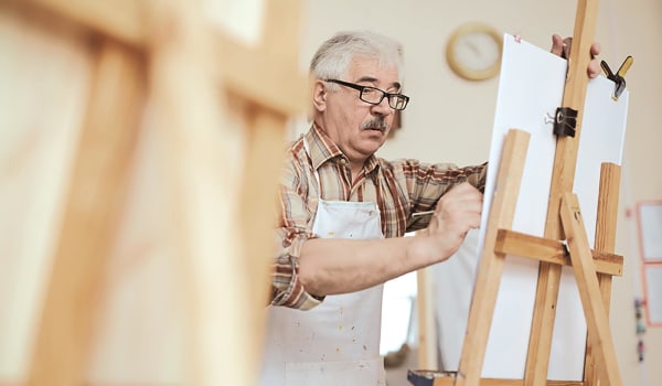 Elderly man working on a painting at Anthology of Tanglewood in Houston, Texas