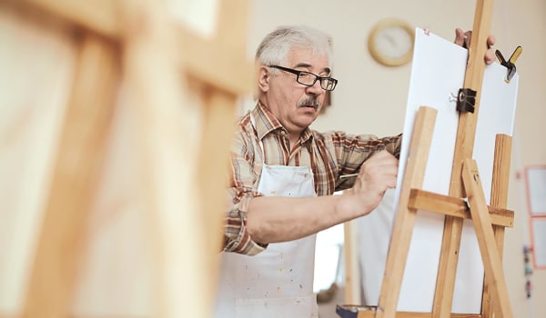Elderly man working on a painting at Anthology of Northville in Northville, Michigan