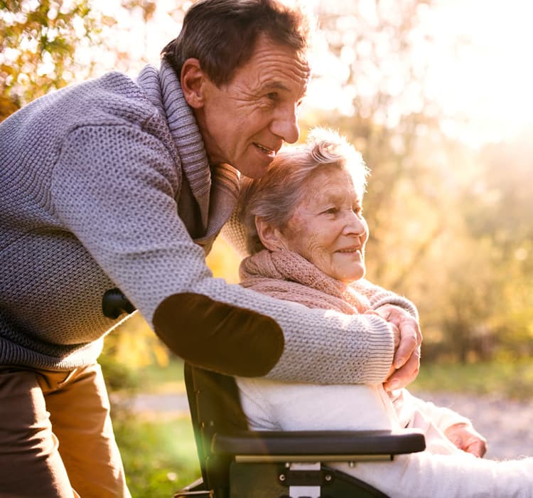 Senior hugging another senior in a wheelchair at MBK Senior Living in Irvine, California
