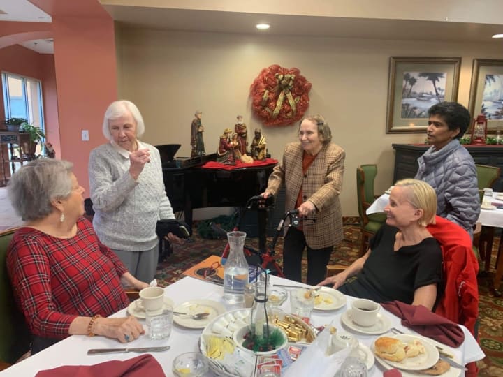 guest pianist visits with residents in the dining room after a luncheon