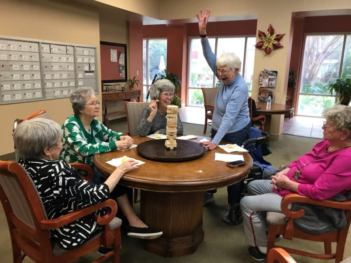 women at a round table playing Jenga