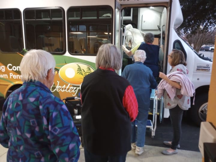 senior adults getting on to the Wesley Haven Villa community bus