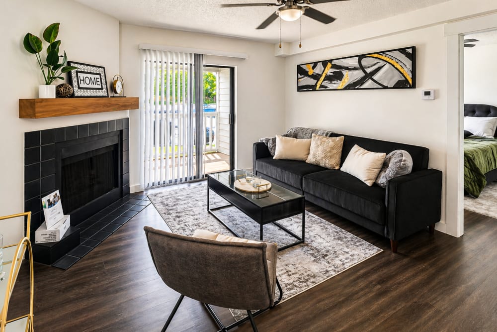 Modern living room with hard-wood flooring and attached patio at Savannah Square & Savannah Harbor in Norman, Oklahoma