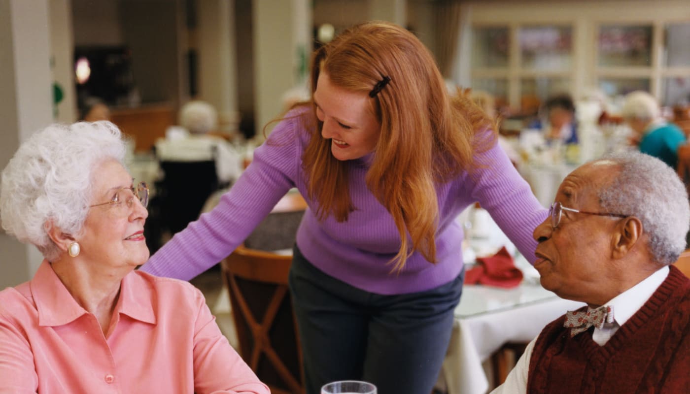 Residents and community staff catching up over coffee at Carolina Assisted Living in Appleton, Wisconsin.