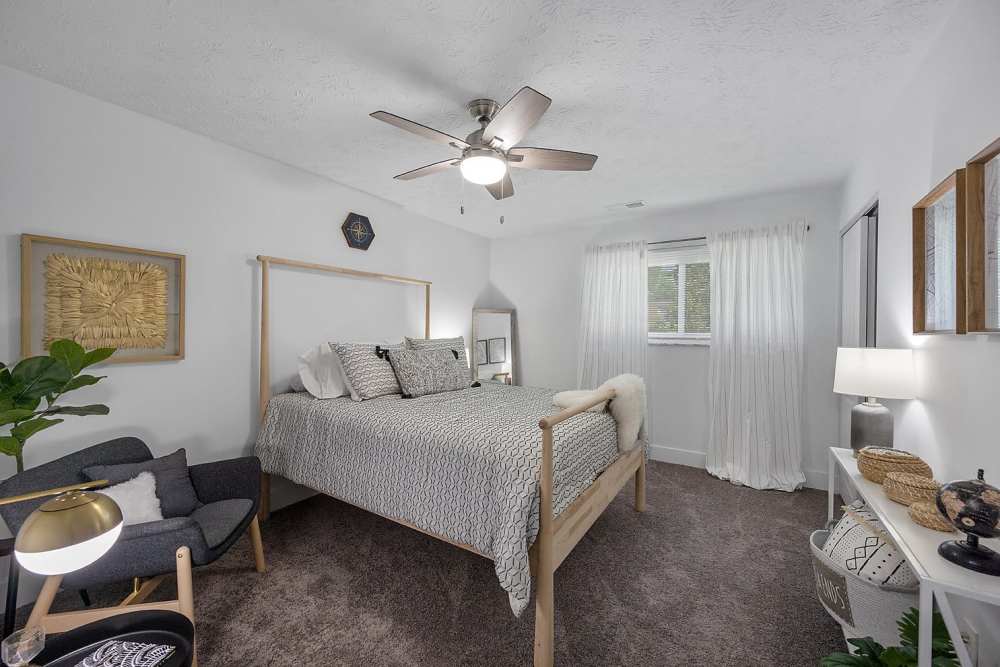 Bedroom with a comfortable bed and a ceiling fan at Millcroft Apartments & Townhomes in Milford, Ohio