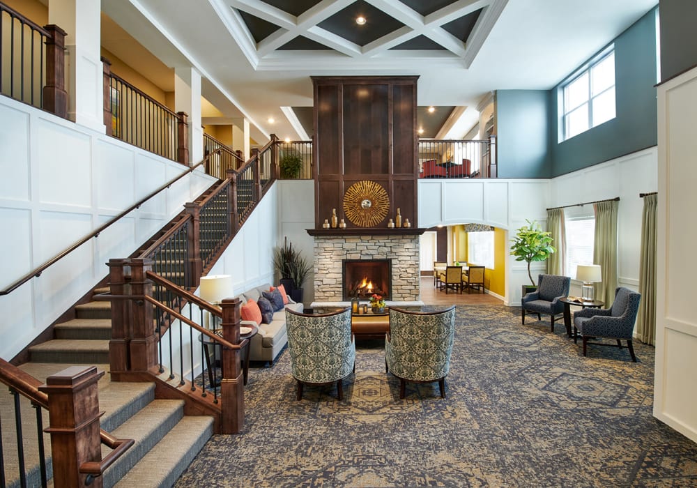 Lobby with a fireplace and stairs leading to the second floor at an Amira Choice community