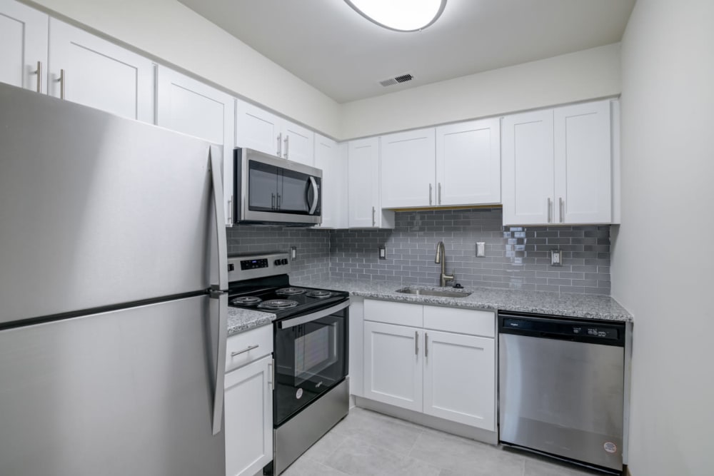 Kitchen with white cabinets and stainless appliances at Tory Estates Apartment Homes in Clementon, New Jersey