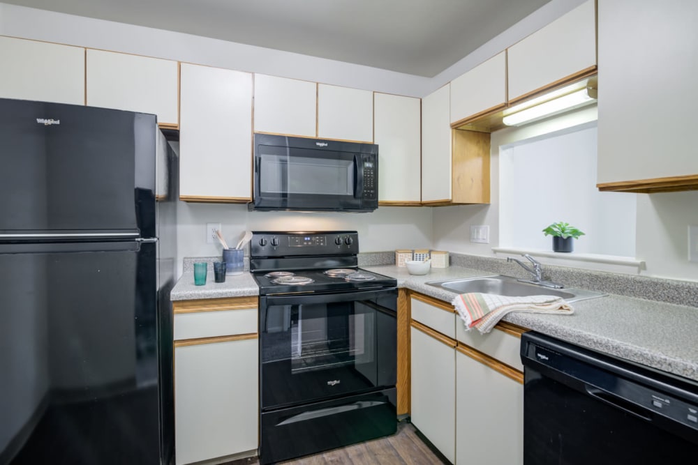 Kitchen with classic cabinets and black appliances at Tory Estates Apartment Homes in Clementon