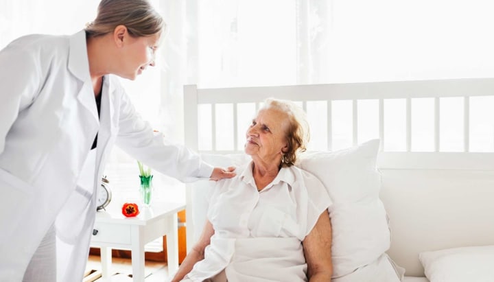 Physician visiting senior woman in bed