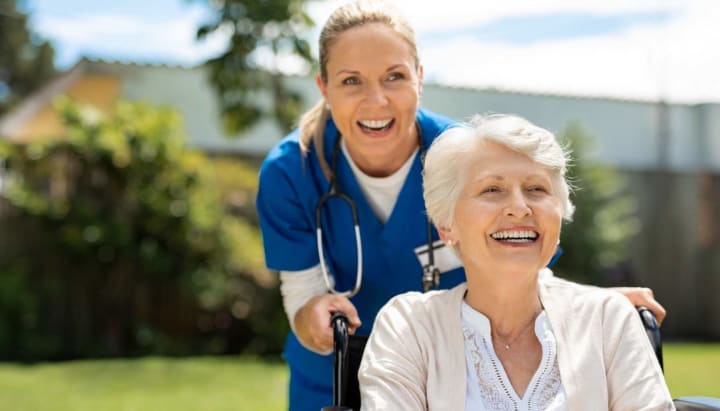 Nurse pushing senior woman in a wheelchair