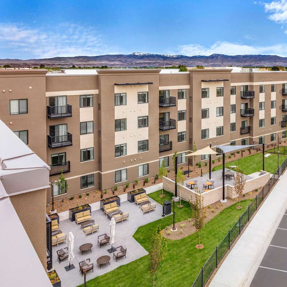 Modern apartment building with balconies and landscaped outdoor seating areas at WaterWalk Boise - Meridian in Meridian, Idaho