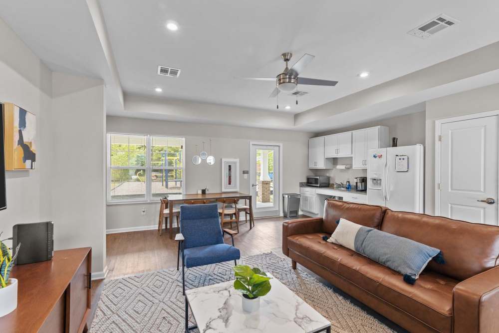 Open layout living area with hardwood flooring, modern kitchen, and access to outdoor patio at Old Firetower Place in Greenville, North Carolina