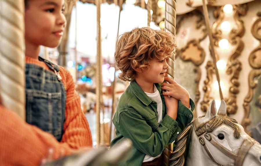 Kids riding a carousel near Messina Luxury Apartments in New Smyrna Beach, Florida