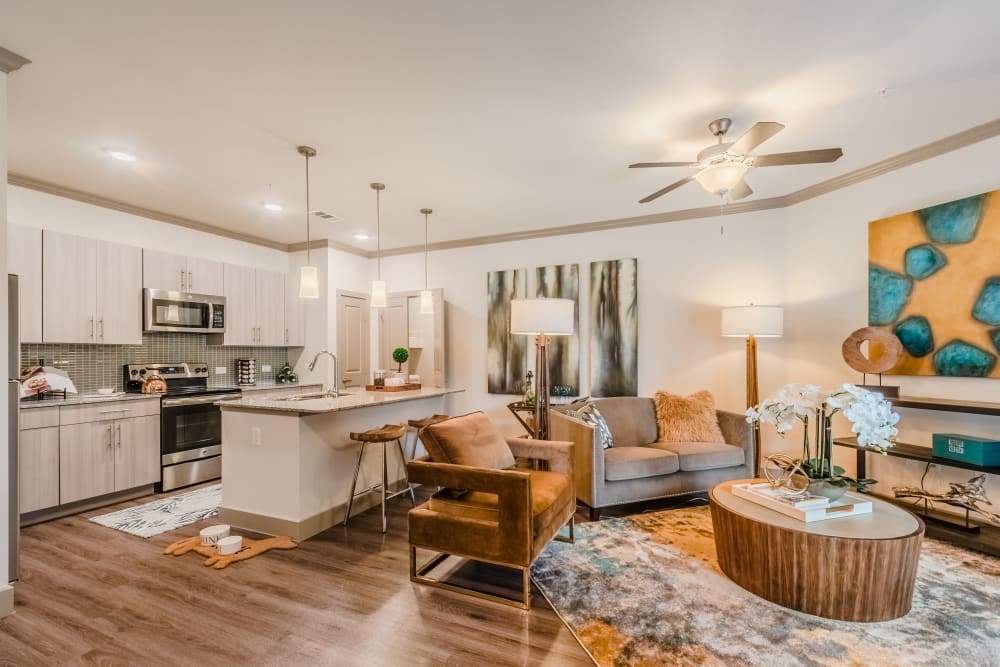 Kitchen and living room in a residence at Atlas Point at Prestonwood in Carrollton, Texas.