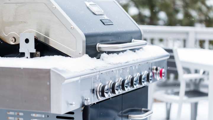 Outdoor grill covered in snow during winter
