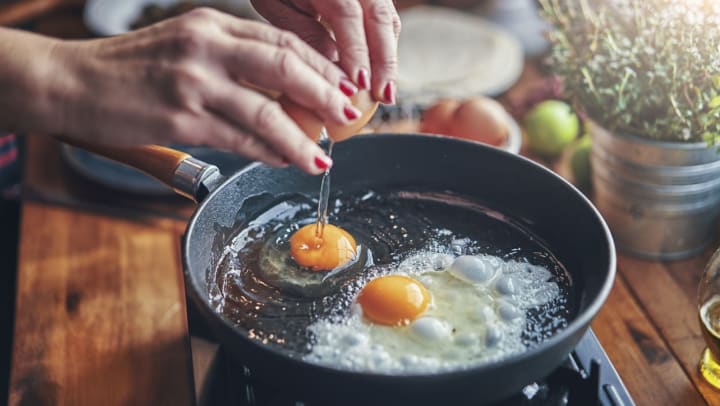 Cracking eggs into a pan