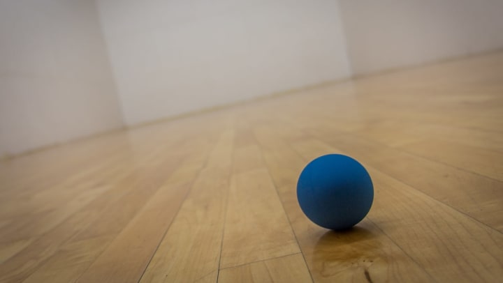 Close-up of a blue racquetball laying on a racquetball court in Albuquerque.