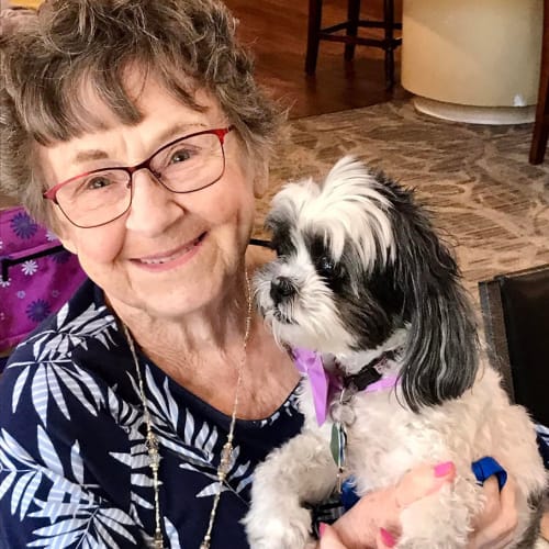 A happy resident with her dog at Oxford Senior Living in Wichita, Kansas